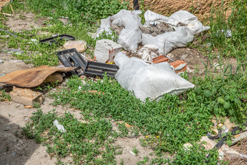 Garbage dump on the grass near the forest ecological disaster concept polluting nature and city park with litter and junk 