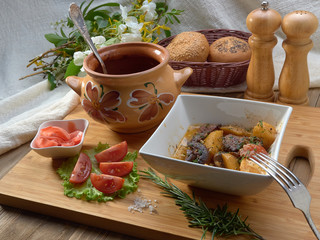 Stewed meat in a ceramic pot with potatoes,champignons,tomatoes and potatoes 