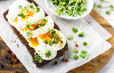 Rye bread sandwich with boiled egg, cheese, freshly ground pepper and daikon or radish sprouts. Delicious gourmet Breakfast. Selective focus - 268535101