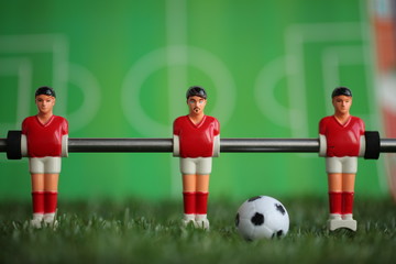 Red foosball plastic players. Soccer ball