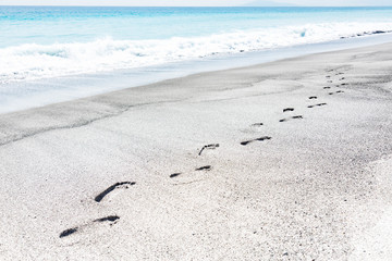 Footmarks on a beach in summer.