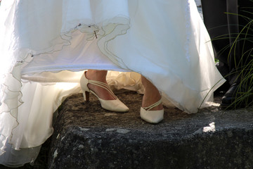 Die Braut trägt weiße Damenschuhe unter ihrem Brautkleid