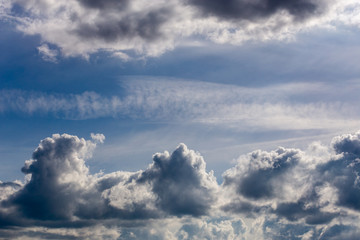 distant misty backlit cumulus and feather clouds near horizon closeup telephoto shot with...