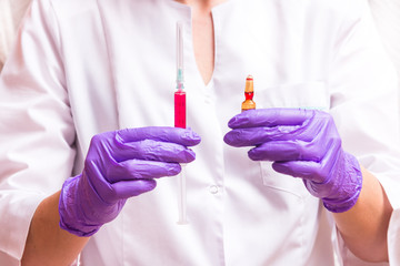 Woman hand holding syringe and ampule