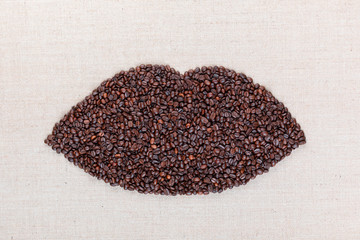 Closed lips made with coffee beans shot from above, aligned in the center.