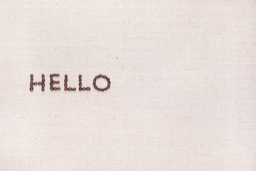 The word Hello written with coffee beans shot from above, aligned to the left.