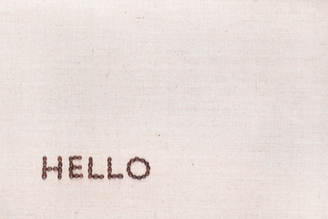 The word Hello written with coffee beans shot from above, aligned at the bottom left.