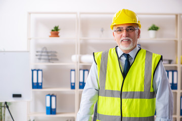 Aged construction engineer working in the office 