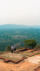 Senior old couple travellers overlooking the landscape on top of Sigiriya Lion's Rock in Sri Lanka