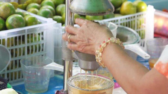Hand squeezing an orange with a fruit squeezer 