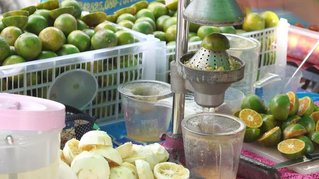 Hand squeezing an orange with a fruit squeezer 