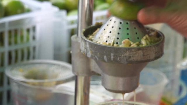 Hand squeezing an orange with a fruit squeezer 