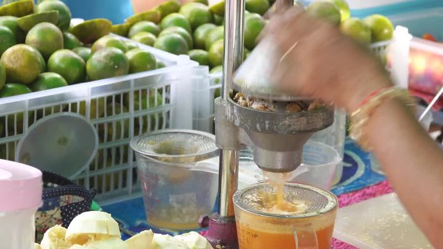 Hand squeezing an orange with a fruit squeezer 