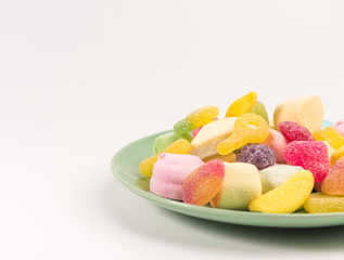 Plate with sweets isolated on a white background. Gummy candies and marshmallow.