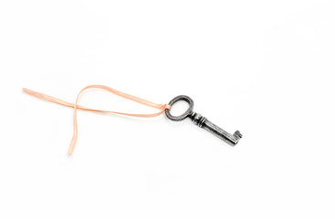 Vintage silver key with pink ribbon on white background