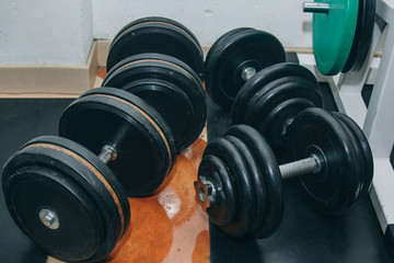 hand metal dumbbells lie on the floor in the gym close-up. training tools