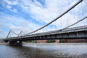 Fototapeta na wymiar Moscow, Russia - May 13, 2019: Crimean Bridge (Krymsky Most) across the Moskva river against the blue cloudy sky. The view from the embankment
