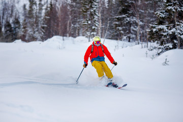 Concept extreme winter sport. Man skier high speed rides on fresh snow, dust in air
