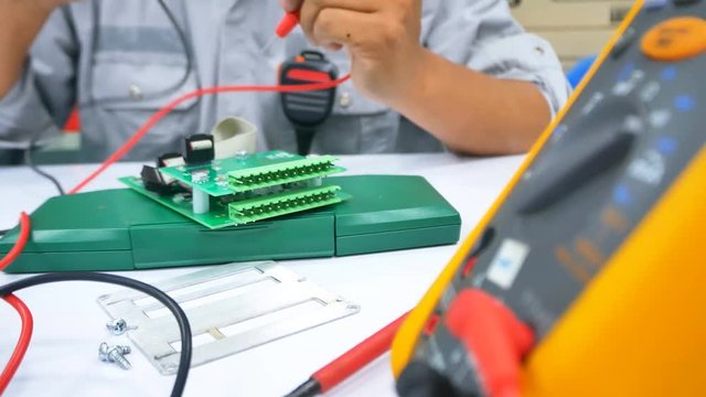 Hand close up of Electrical engineer to check Electric Part on work desk