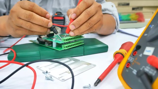 Hand close up of Electrical engineer to check Electric Part on work desk