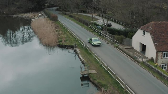 Cruising through countryside in a CSL car at Surrey hills England, drone shot