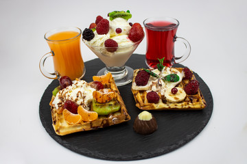 A set of different sweets. Waffles, ice cream, berries and juice on a white background. Food background.