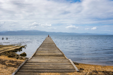 Fototapeta premium Woman resting on a old dock at the gulf of Cariaco in Venezuela