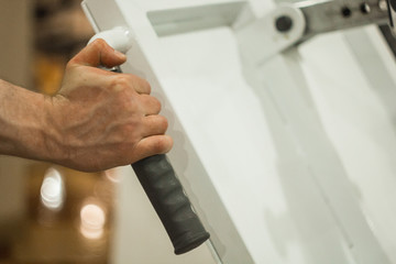 Obraz premium The athlete holds his hands on the hilt of the training machine in the training center. training tools in the gym close-up