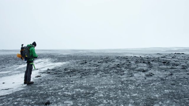 Adventure Tourist, Man Stands in Frozen Iceland Landscape.