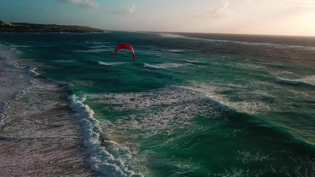Drone showing Kite surfer fighting against the waves near the coast.