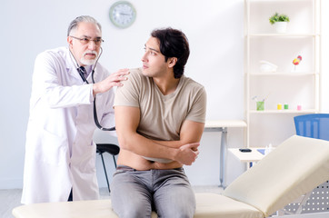 Young male patient visiting old doctor 