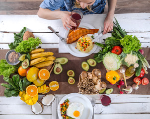 The woman at the dinner table with organic food , the view from the top.