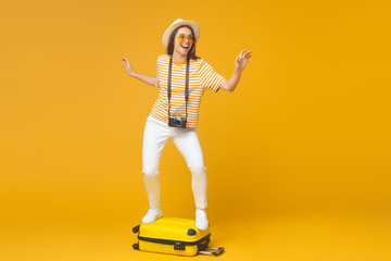 Young positive woman pretending she is flying to country of her dream, isolated on yellow background