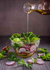 Salad with a mixture of herbs, vegetables and herbs in a glass bowl.
