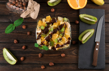 fruits salad with chocolate on wooden background