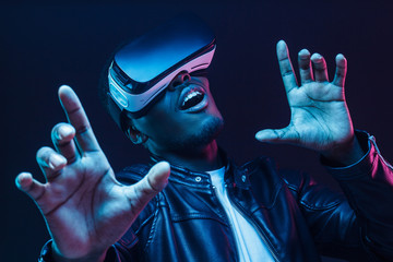 Young African man moving his hands while enjoying virtual reality experience