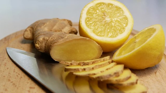 Ginger and lemon rotate on a cutting board and stop