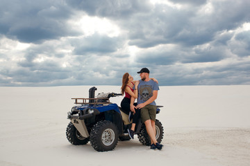 girl hugs her boyfriend on a quad in the desert, a loving couple enjoys each other