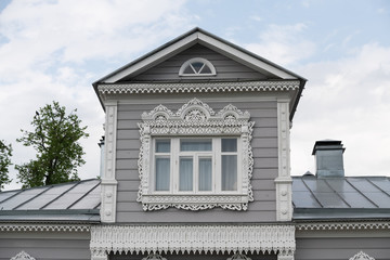 Old wooden house with white carved wooden shutters and decorative elements