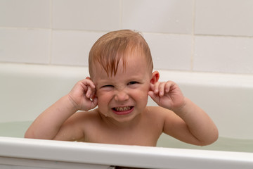 Little boy 3 years old bathes in the bath