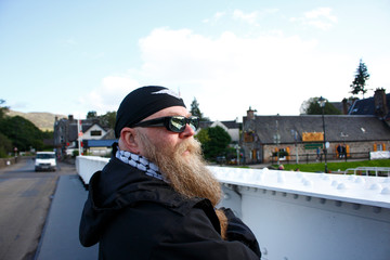 Mann mit langem Bart, Brille und Kopftuch, steht nachdenklich an der Schleuße am Caledonian Canal