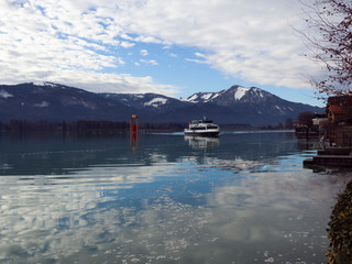 Vistas del lago Wolfgangsee con un barco y al fondo las montañas nevadas, en invierno de 2018