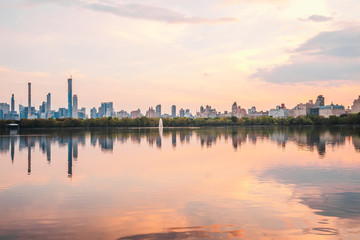 Fototapeta na wymiar Sunset View of Manhattan skyline from Jacqueline Kennedy Onassis Reservoir in Central Park, reflection in water