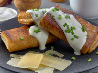 Fried pancakes with meat,sprinkled with green onions and sour cream