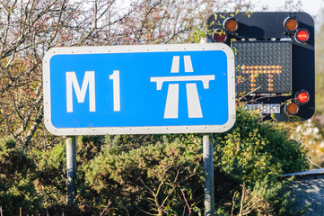 M1 Motorway sign with a road closed sign behind showing both lanes are closed due to an accident.
