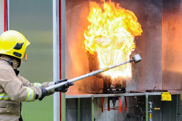 A fireman demonstrates the result of pouring a small amount of water onto a burning chip pan in a...