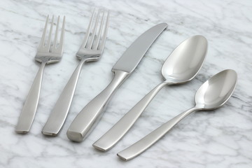 beautiful silverware on carrara marble