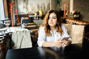 Portrait of beautiful girl using her mobile phone in cafe.