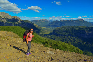 chica con mochila caminando por las montañas