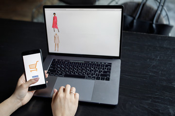 Woman with phone. Online payment. Women hands using smartphone and laptop computer for online shopping. Payment Detail page display.